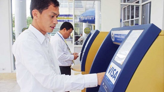 a-man-withdraws-part-of-his-monthly-salary-from-an-atm-in-the-capital-in-2015.-heng-chivoan